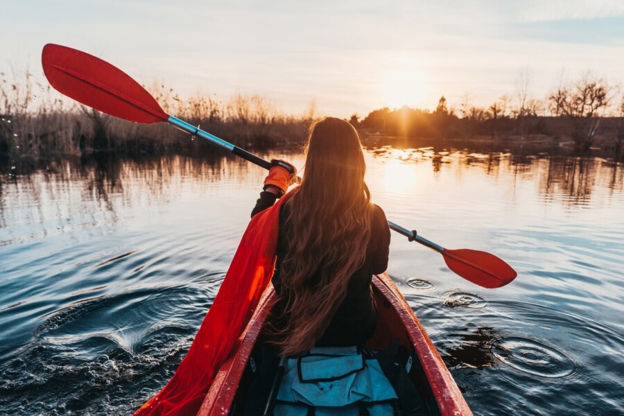 Woman holding paddle in a kayak on the river-best places to kayak in Colorado